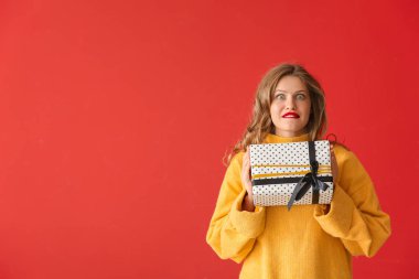 Renkli arka planda Noel hediyesi ile Mutlu genç kadın