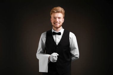 Koyu arka plan üzerinde yakışıklı garson