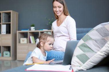 Evde kızı ile çalışan hamile anne