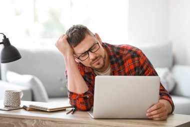 Ofiste masada dizüstü bilgisayar ile Stresli adam