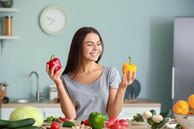 Mutfakta yemek pişiren güzel genç bir kadın.