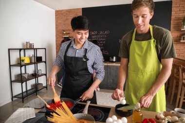 Yakışıklı erkekler mutfakta birlikte yemek yapıyor