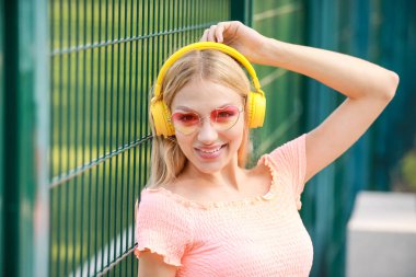 Güzel genç kadın müzik açık havada için dinleme