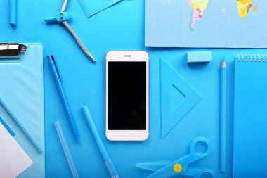 Renkli arka planda harita ve kırtasiye ile modern cep telefonu