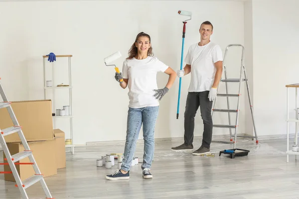 Feliz jovem casal fazendo reparação no quarto — Fotografia de Stock