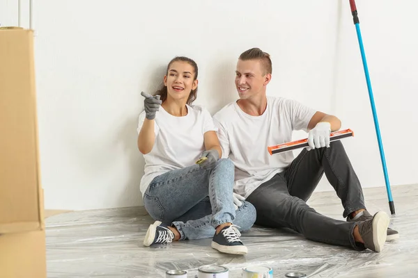 Feliz jovem casal discutindo reparação de sua nova casa — Fotografia de Stock