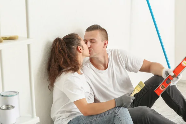 Junges Paar küsst sich bei Reparatur seines neuen Hauses — Stockfoto
