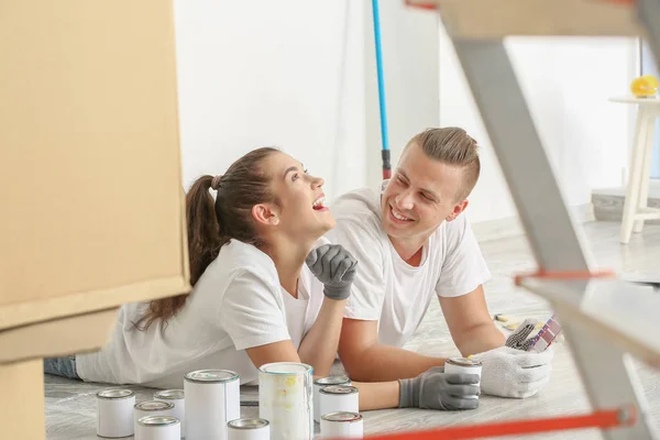 Casal jovem feliz escolhendo a cor da pintura de paredes na sua nova casa — Fotografia de Stock