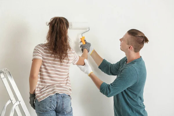 Feliz jovem casal fazendo reparação em sua nova casa — Fotografia de Stock