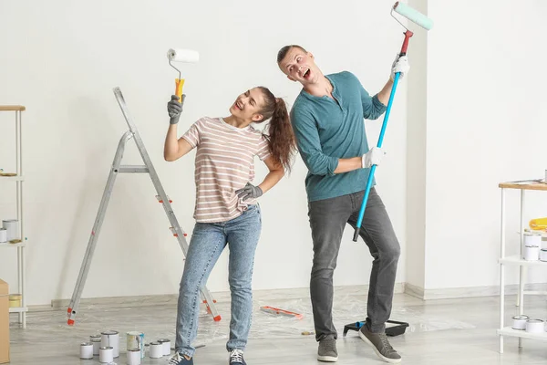 Feliz joven pareja divirtiéndose mientras hace la reparación en su nueva casa — Foto de Stock