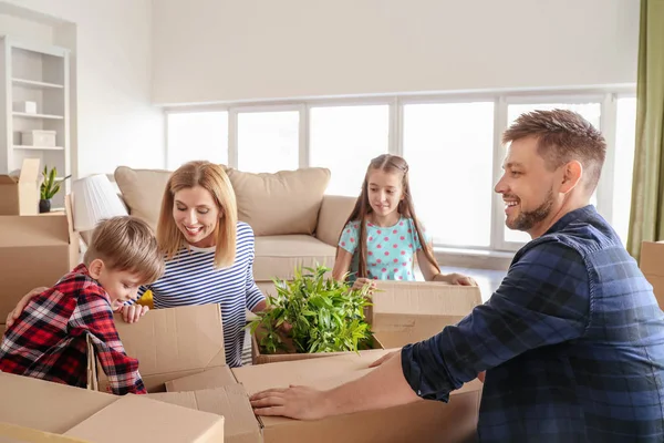 Familia feliz desempacando pertenencias en su nueva casa —  Fotos de Stock