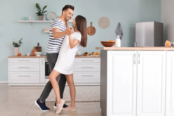 Šťastný mladý pár tanec v kuchyni — Stock fotografie