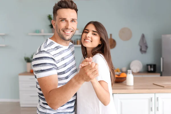 Feliz pareja joven bailando en la cocina —  Fotos de Stock