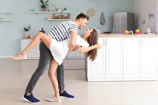 Feliz pareja joven bailando en la cocina —  Fotos de Stock