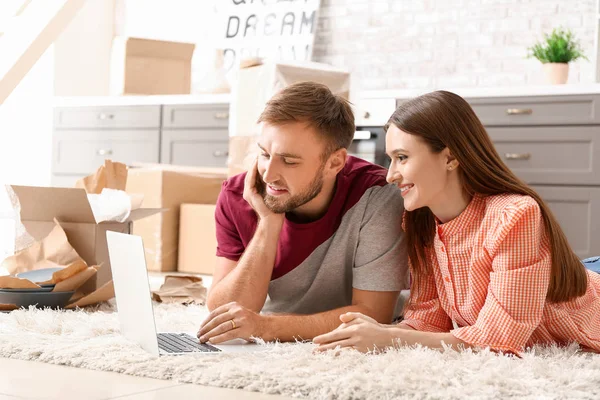 Young couple with laptop planning design of their new house — Stock Photo, Image