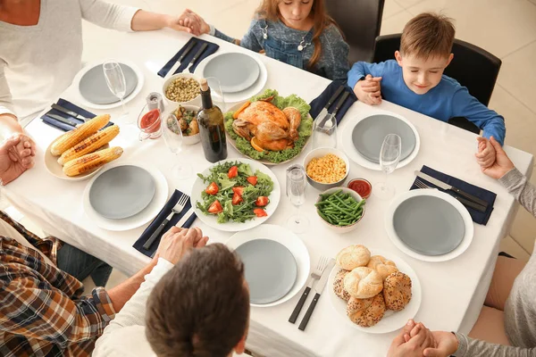 Family praying before having Christmas dinner at home — Stock Photo, Image