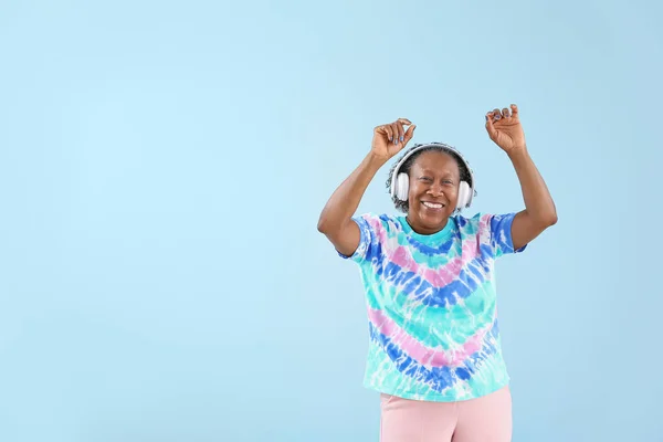 Retrato de mujer afroamericana escuchando música y bailando sobre fondo de color — Foto de Stock