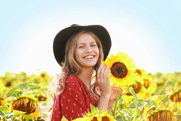 Beautiful young woman in sunflower field on summer day — Stock Photo, Image