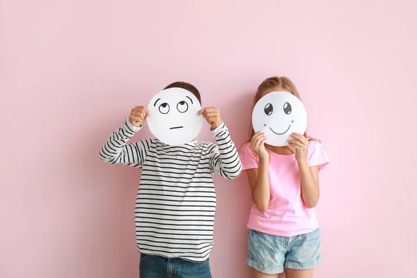 Little children hiding faces behind drawn emoticons on color background — Stock Photo, Image