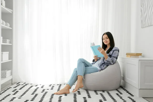 Krásná mladá žena čtení knihy doma — Stock fotografie