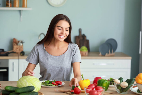 Beautiful young woman cooking in kitchen