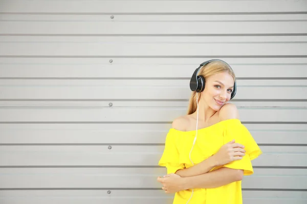 Mooie jonge vrouw luisteren aan muziek in openlucht — Stockfoto
