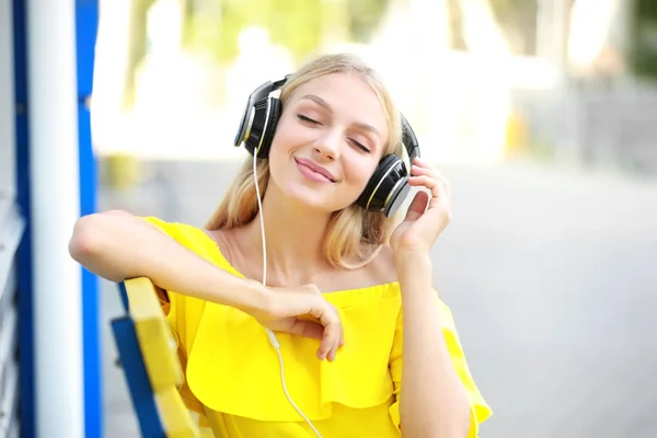 Mooie jonge vrouw luisteren aan muziek in openlucht — Stockfoto