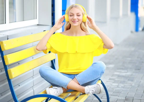 Beautiful young woman listening to music outdoors — Stock Photo, Image