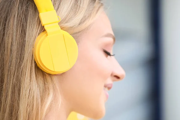 Beautiful young woman listening to music outdoors — Stock Photo, Image