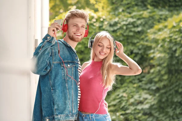 Pareja joven escuchando música al aire libre — Foto de Stock