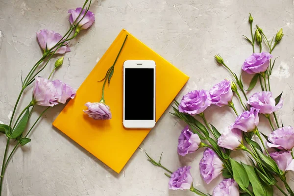 Modern mobile phone with flowers and notebook on grunge background — Stock Photo, Image