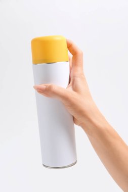 Hafif arka planda hava spreyi şişesi ile Kadın el