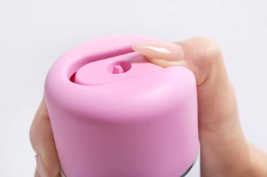 Hafif arka planda hava spreyi şişesi ile kadın el, closeup