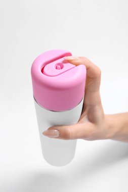 Hafif arka planda hava spreyi şişesi ile Kadın el