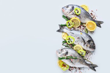 Beyaz arka planda taze dorado balık ve baharatlar