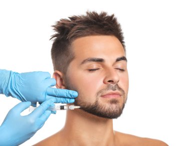 Beyaz arkaplanda doldurucu enjeksiyon alan yakışıklı adam