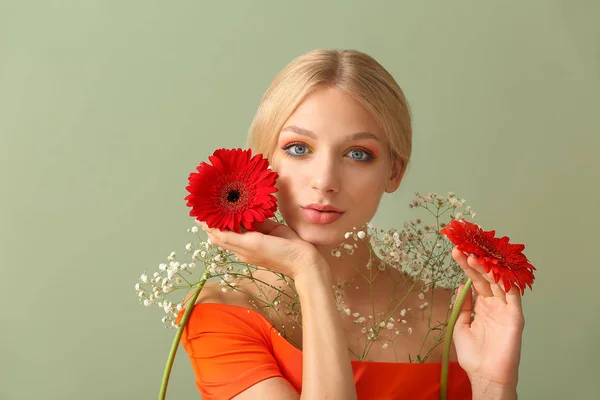 Vacker ung kvinna med blommor på färg bakgrund — Stockfoto