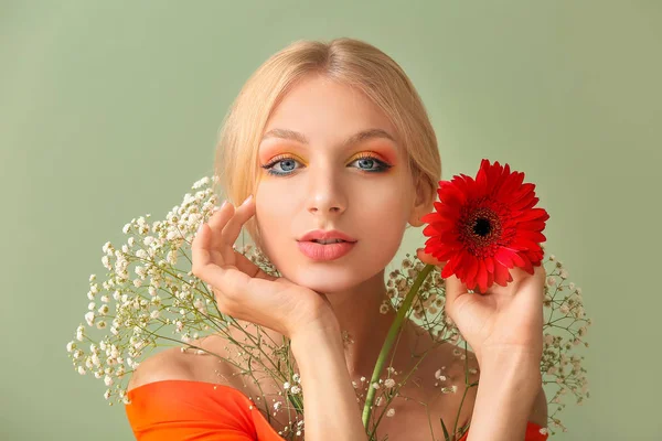 Beautiful young woman with flowers on color background — Stock Photo, Image