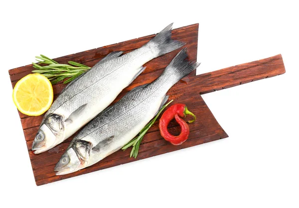 Board with fresh seabass fish, rosemary, chili pepper and lemon on white background — Stock Photo, Image