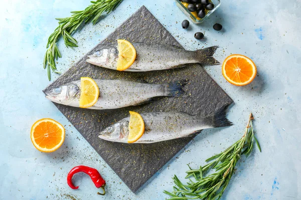 Komposition med färsk Seabass fisk på färg bakgrund — Stockfoto
