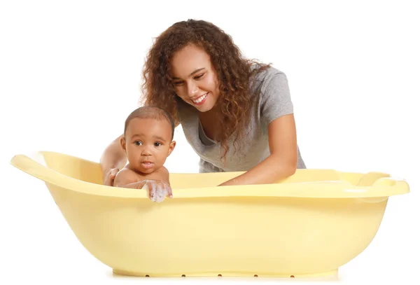 Ibu muda Afrika-Amerika mencuci bayinya di bak mandi dengan latar belakang putih — Stok Foto