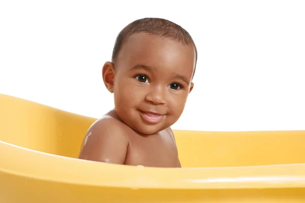 Little African-American baby washing in bathtub against white background — Stock Photo, Image