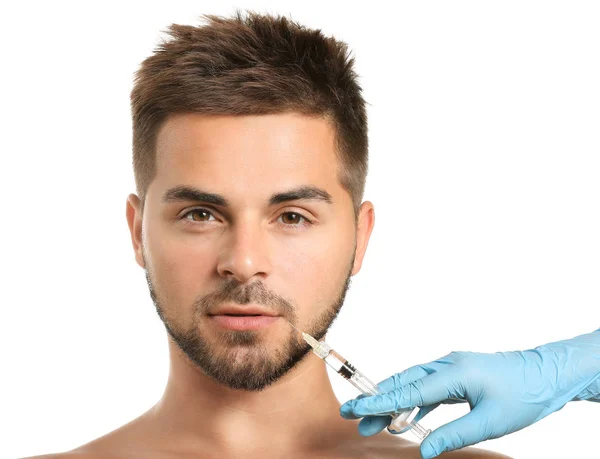 Bonito homem recebendo injeção de enchimento no fundo branco — Fotografia de Stock