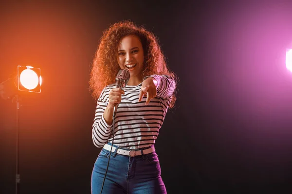 Hermosa cantante afroamericana con micrófono en el escenario — Foto de Stock