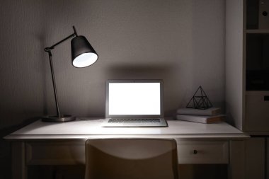 Akşam dizüstü bilgisayar ile modern işyeri