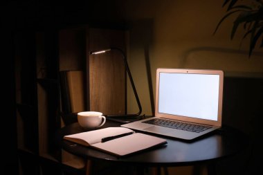 Akşam dizüstü bilgisayar ile modern işyeri