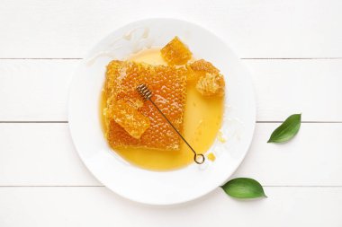 Beyaz ahşap arka planda bal tarakları ile plaka