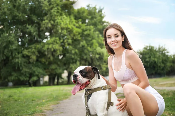 Sporty young woman with cute dog in park — Stock Photo, Image