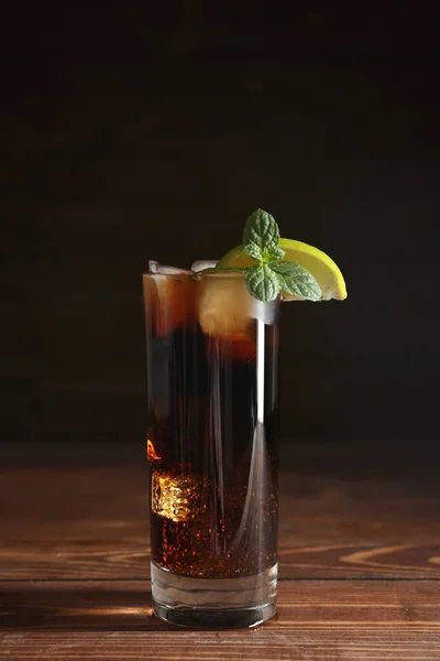 Bicchiere di cola fresca con ghiaccio sul tavolo di legno — Foto Stock