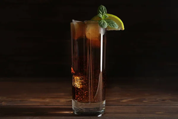 Copo de cola fresca com gelo na mesa de madeira — Fotografia de Stock